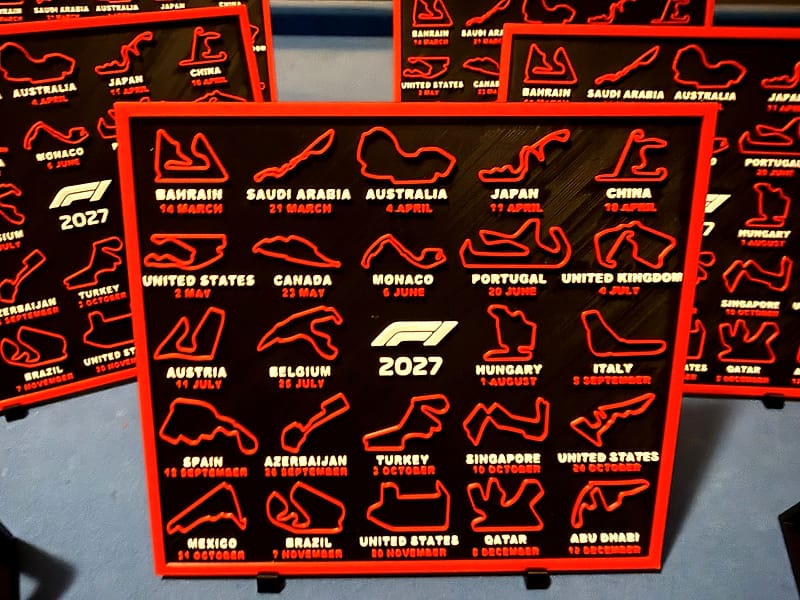 De 2027 3D race kalender rechtop op twee zwarte standaards, met meerdere kalenders op de achtergrond